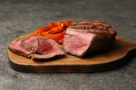 Delicious grilled beef steak with spices on gray table, closeup