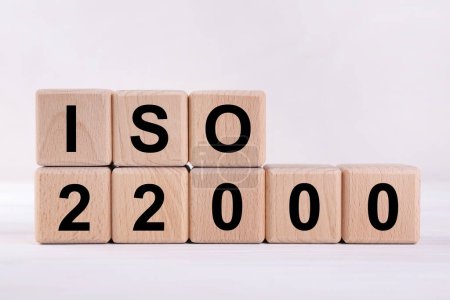 Organisation internationale de normalisation. Cubes en bois avec abréviation ISO et numéro 22000 sur table blanche