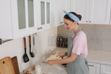 Lächelnde Frau beim Kochen in der Küche. Schmutziges Geschirr und Utensilien auf unordentlicher Arbeitsplatte