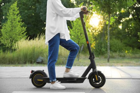 Photo for Woman with modern electric kick scooter in park, closeup - Royalty Free Image