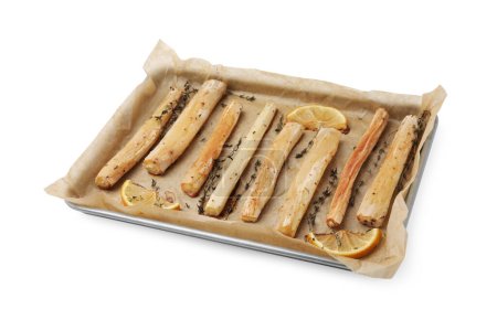 Baking tray with cooked salsify roots, lemon and thyme isolated on white