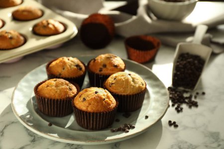 Photo for Delicious sweet muffins with chocolate chips on white marble table - Royalty Free Image