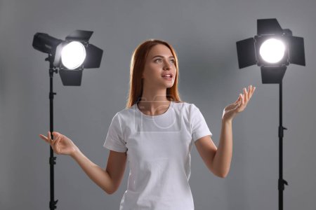 Casting call. Emotional woman performing on grey background in studio