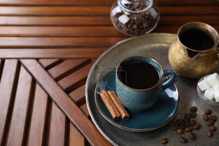 Turkish coffee. Freshly brewed beverage served on wooden table, space for text