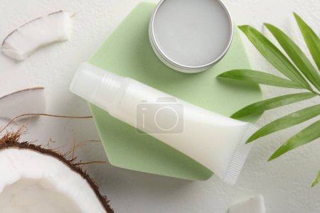Photo for Lip balms, coconut and leaves on white background, flat lay - Royalty Free Image