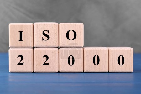 Organisation internationale de normalisation. Cubes avec abréviation ISO et numéro 22000 sur table en bois bleu