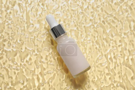 Photo for Bottle of cosmetic serum on beige background, top view - Royalty Free Image