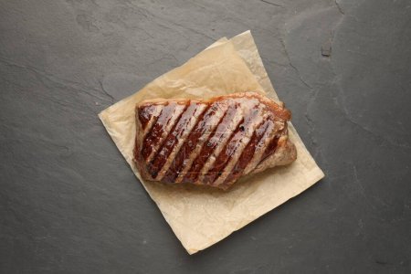 Delicious grilled beef steak on dark gray table, top view