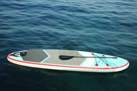 Photo for One SUP board with paddle on water in sea, space for text - Royalty Free Image