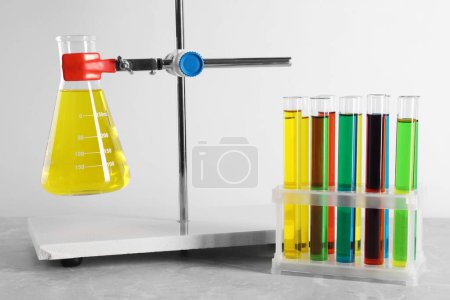 Laboratory glassware with liquids on table against white background