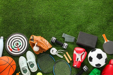 Téléchargez les photos : Différents équipements sportifs et baskets sur herbe verte, plat. Espace pour le texte - en image libre de droit