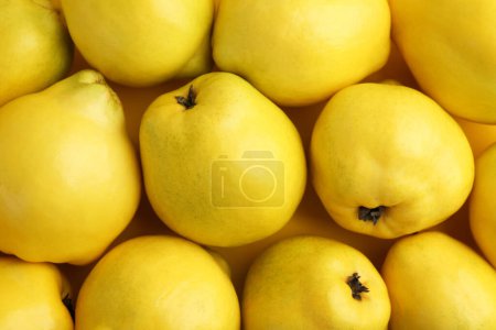 Delicious ripe quinces as background, top view