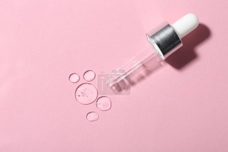 Photo for Clear cosmetic serum and pipette on pink background, top view - Royalty Free Image