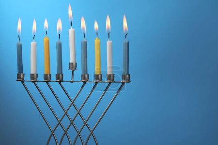 Téléchargez les photos : Hanoukka fête. Menorah avec des bougies allumées sur fond bleu clair, espace pour le texte - en image libre de droit