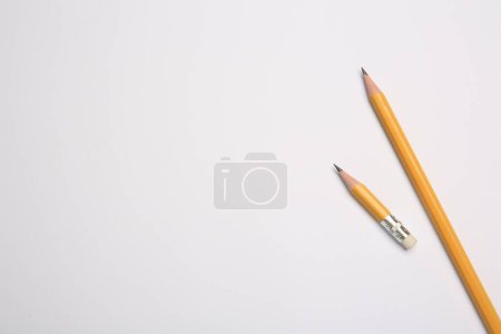 Graphite pencils on white background, flat lay. Space for text