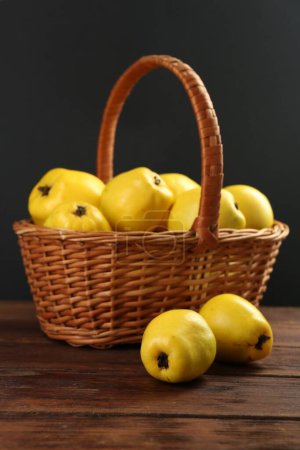 Basket with delicious ripe quinces on wooden table