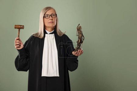 Senior judge with gavel and figure of Lady Justice on green background. Space for text