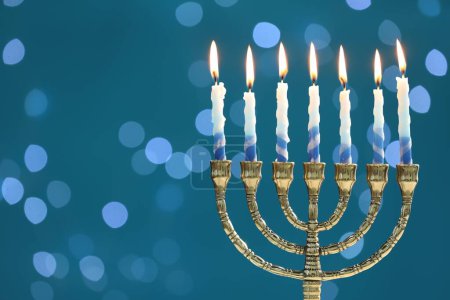 Téléchargez les photos : Hanoukka fête. Menorah avec des bougies allumées sur fond bleu avec des lumières floues, espace pour le texte - en image libre de droit