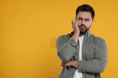 Photo for Resentful man on orange background. Space for text - Royalty Free Image