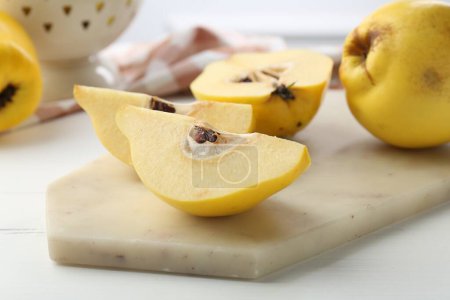 Tasty ripe quinces on white wooden table, closeup