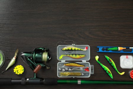 Photo for Fishing tackle on dark wooden background, flat lay. Space for text - Royalty Free Image