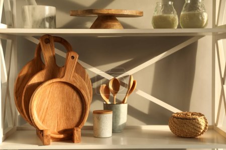 Foto de Tableros de madera para cortar, utensilios de cocina y decoración en estanterías - Imagen libre de derechos