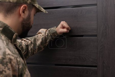 Photo for Military commissariat representative knocking on wooden door, selective focus - Royalty Free Image