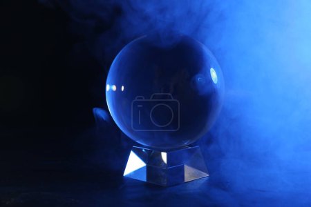 Photo for Magic crystal ball on table and smoke against dark background. Making predictions - Royalty Free Image