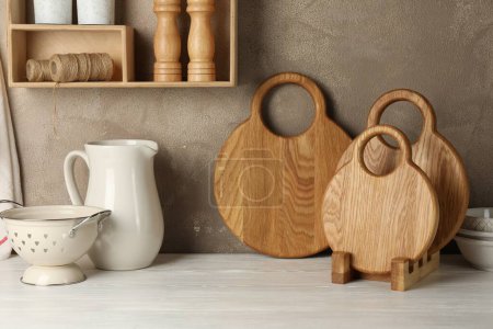 Foto de Tableros de madera y vajilla de cocina sobre mesa blanca - Imagen libre de derechos