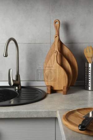 Foto de Tableros de corte de madera y otros utensilios de cocina en encimera gris claro en la cocina - Imagen libre de derechos