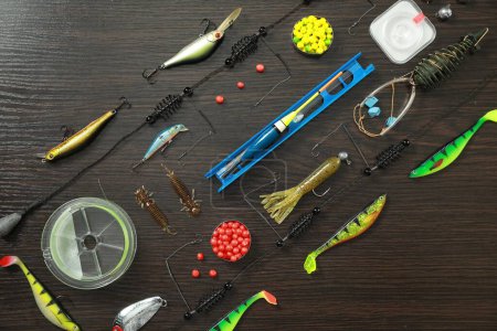 Photo for Fishing tackle on dark wooden background, flat lay - Royalty Free Image