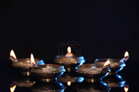 Photo for Many lit diyas on black background, space for text. Diwali lamps - Royalty Free Image