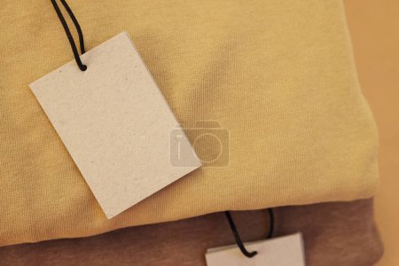 Foto de Etiquetas de cartón en la prenda, primer plano. Espacio para texto - Imagen libre de derechos