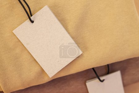 Foto de Etiquetas de cartón en la prenda, primer plano. Espacio para texto - Imagen libre de derechos