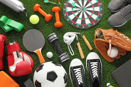 Téléchargez les photos : Différents équipements sportifs et baskets sur herbe verte, pose plate - en image libre de droit