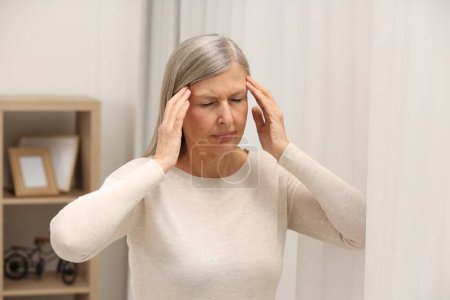 Photo for Menopause. Woman suffering from headache at home - Royalty Free Image