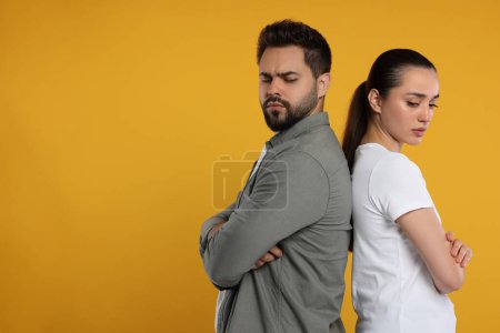 Photo for Resentful couple with crossed arms on orange background, space for text - Royalty Free Image