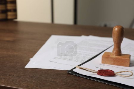 Téléchargez les photos : Documents et timbre sur table en bois, gros plan avec espace pour le texte. Contrat notarié - en image libre de droit