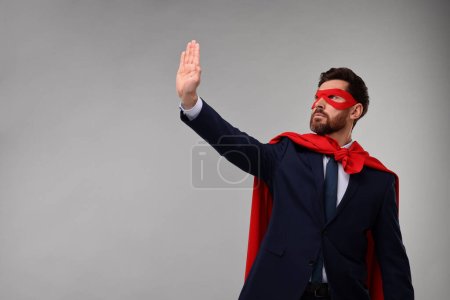 Foto de Hombre de negocios confiado con capa de superhéroe rojo y máscara sobre fondo beige. Espacio para texto - Imagen libre de derechos
