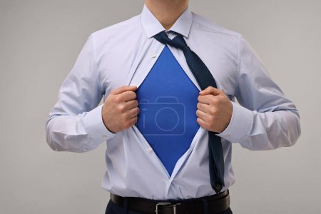 Foto de Hombre de negocios con traje de superhéroe debajo del traje sobre fondo beige, primer plano - Imagen libre de derechos