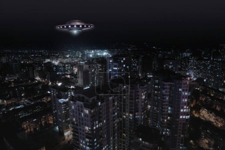 Nave espacial alienígena volando sobre la ciudad por la noche. OVNI, visitantes extraterrestres