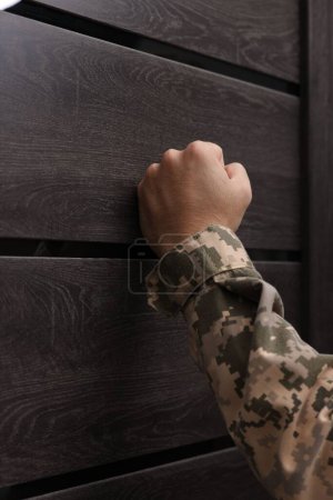 Photo for Military commissariat representative knocking on wooden door, closeup - Royalty Free Image