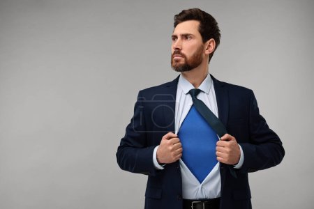 Foto de Hombre de negocios confiado usando traje de superhéroe bajo traje sobre fondo beige. Espacio para texto - Imagen libre de derechos