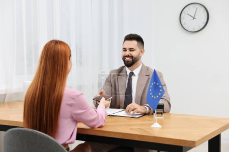 Foto de Inmigración a la Unión Europea. Mujer teniendo entrevista con trabajador de la embajada en la oficina - Imagen libre de derechos