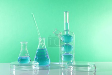 Photo for Laboratory analysis. Different glassware on table against green background - Royalty Free Image