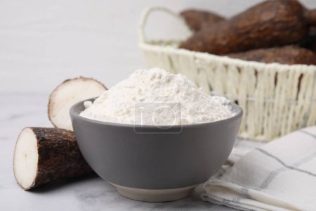Téléchargez les photos : Bol avec farine de manioc et racines sur table en marbre blanc - en image libre de droit