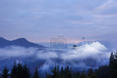 Außerirdische Raumschiffe fliegen in nebligen Bergen. UFO