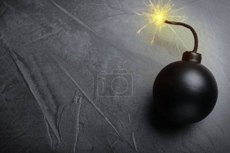 Photo for Old fashioned black bomb with lit fuse on grey table, top view. Space for text - Royalty Free Image