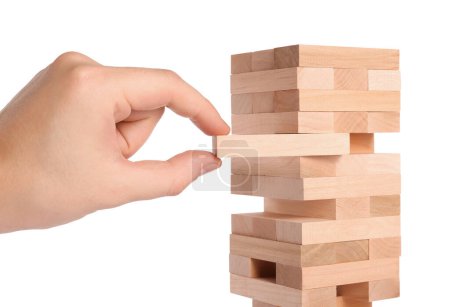 Playing Jenga. Man removing wooden block from tower on white background, closeup