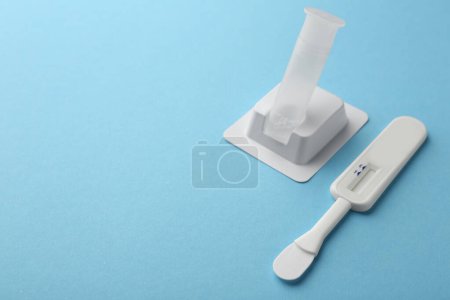Disposable express test kit on light blue background. Space for text